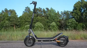 Xiaomi Electric Scooter 6 parkerad i solen på landsväg med skogsbryn i bakgrunden